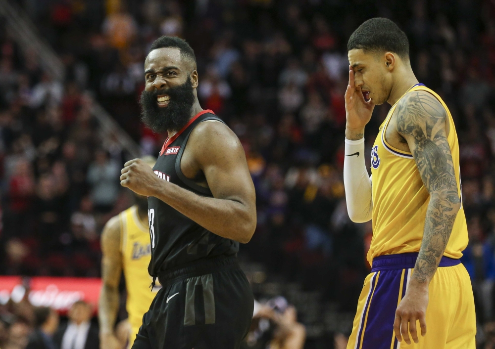 Houston Rockets guard James Harden (13) celebrates and Los Angeles Lakers forward Kyle Kuzma (0) reacts after a play during overtime at Toyota Center. Troy Taormina