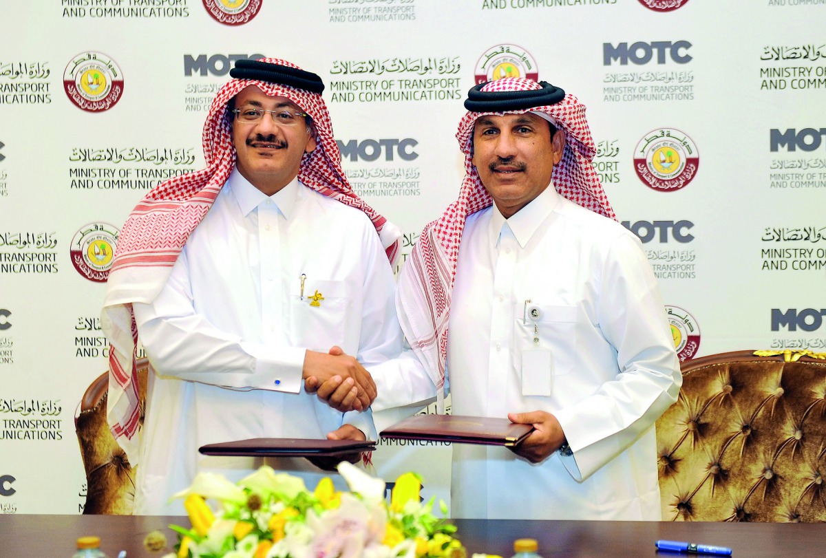 Hassan Al Hail, Adviser to the Minister of Transport and Communications (right) and Faleh Al Naemi, Chairman of Qatar Postal services and Managing Director during the signing ceremony, yesterday. Pic: Abdul Basit / The Peninsula