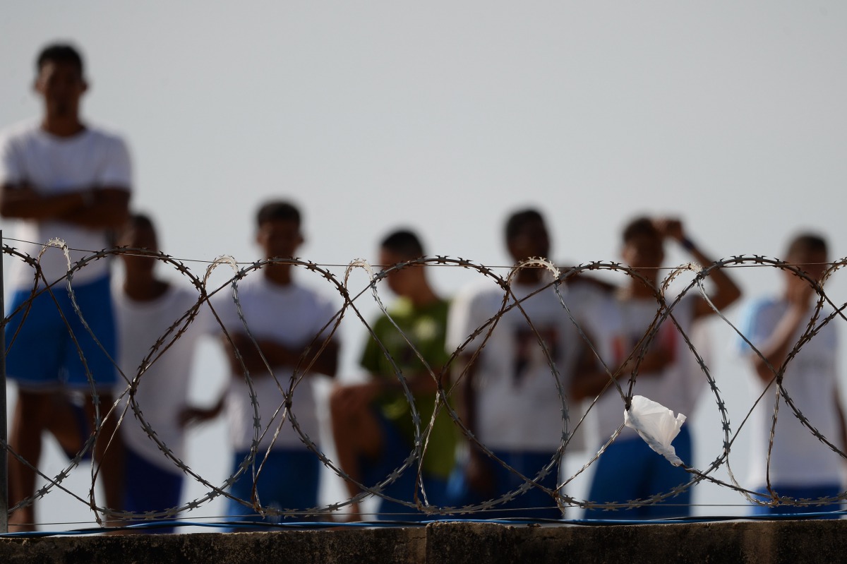 Inmates watching as injured prisoners are removed to receive medical care the day after a battle between gangs in the Alcacuz Penitentiary Center, Brazil, January 20, 2017. AFP/Andressa Anholete