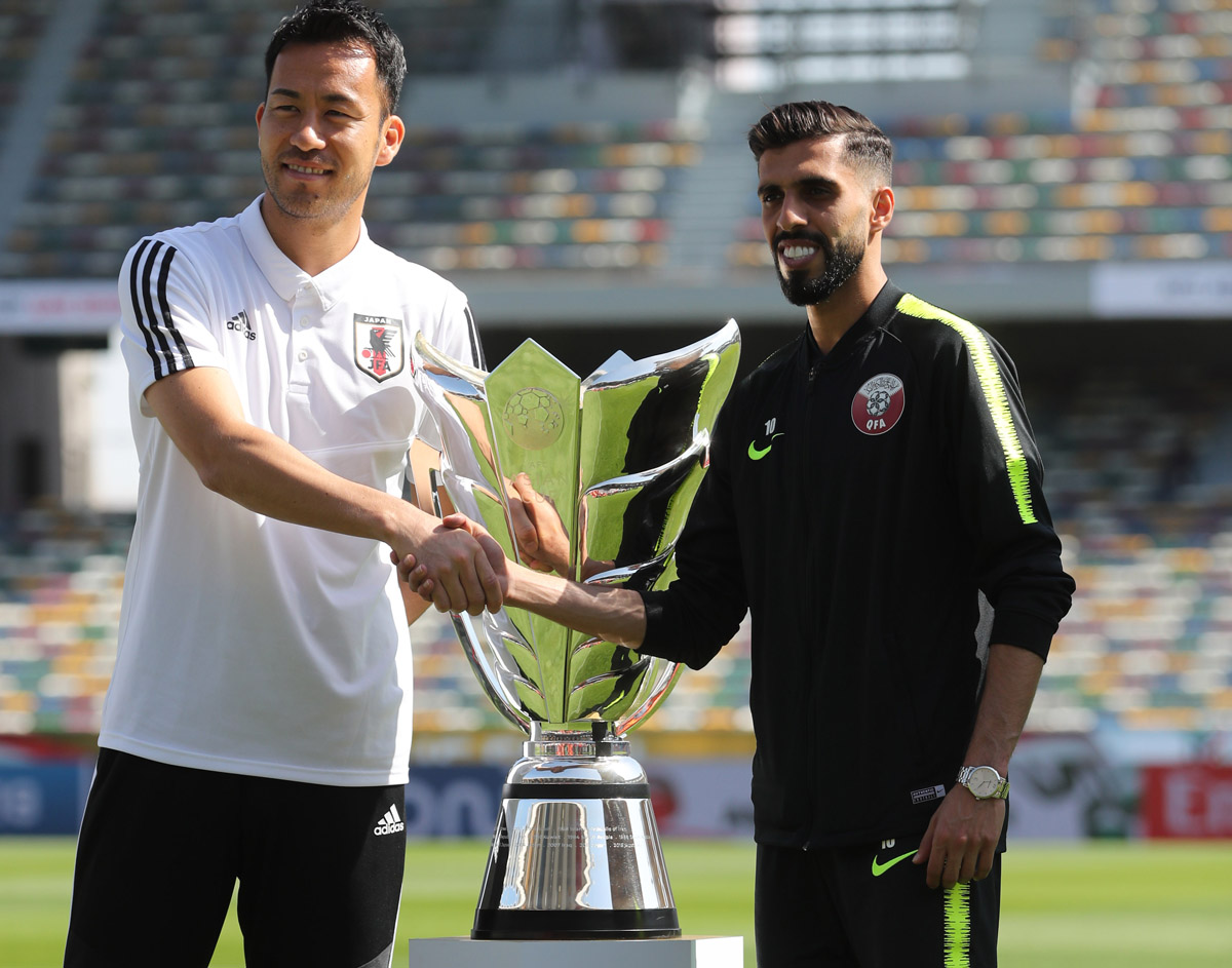 Qatar and Japan football team captains shake hands.