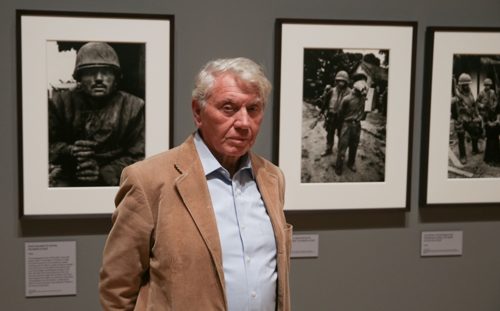 British photographer Don McCullin poses for a picture in front of his photographs including 'Shell-shocked US marine, the Battle of Hue 1968' (L), during a press preview of a retrospective exhibition of McCullin's work at Tate Britain in London on Februar