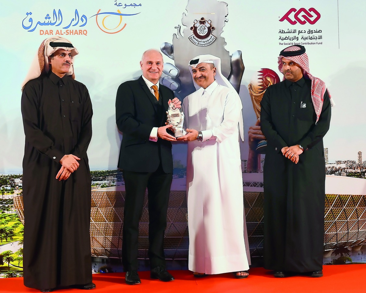 The Minister of Administrative Development, Labour and Social Affairs, H E Yousef bin Mohammed Al Othman Fakhro, presenting a Social Responsibility Award to an official of Occidental Petroleum of Qatar Ltd, as Sheikh Dr Khalid bin Thani Al Thani, the Vice