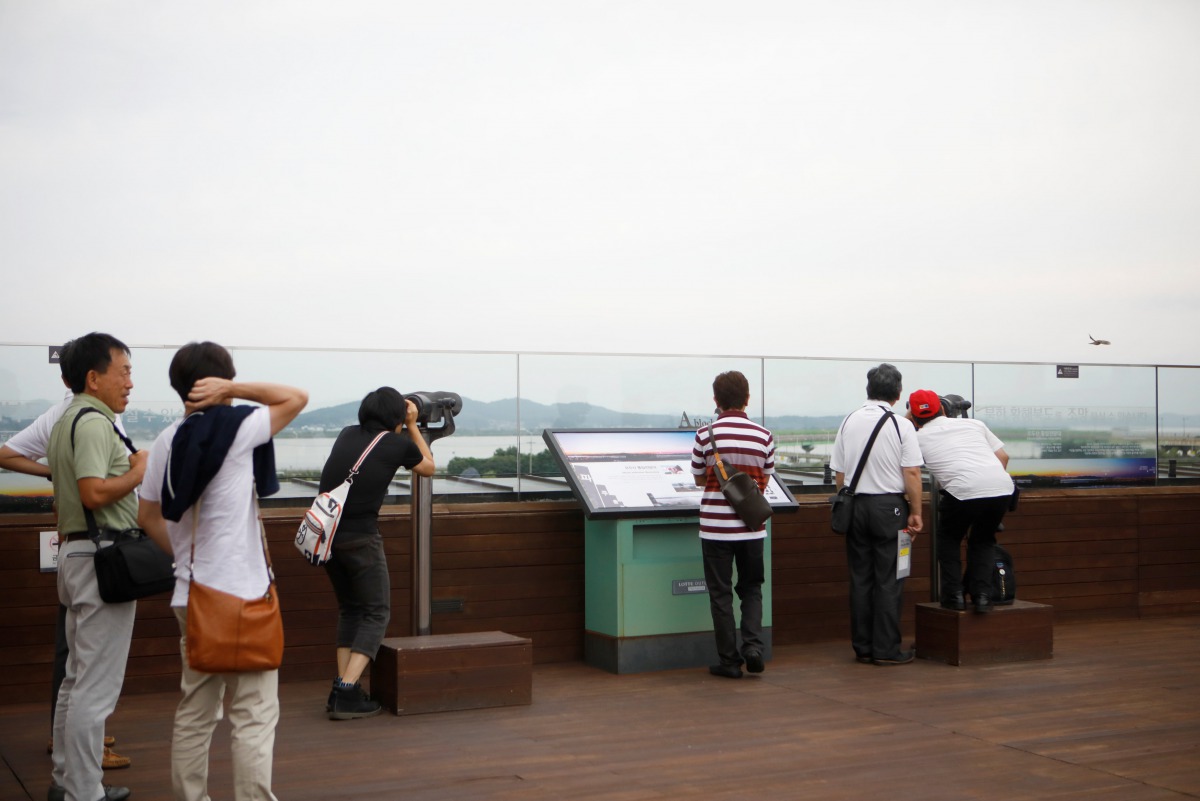 Visitors look toward a North Korean village through a pair of binoculars at a shopping mall near the demilitarized zone separating the two Koreas in Paju, July 16, 2017. Reuters/Kim Hong-Ji