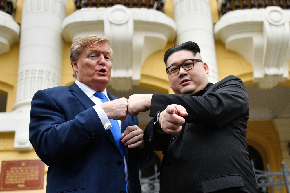 S President Donald Trump impersonator Russel White (L) and North Korean leader Kim Jong Un impersonator Howard X (R) pose together for photographs outside the Opera House in Hanoi on February 22, 2019. / AFP / Manan VATSYAYANA