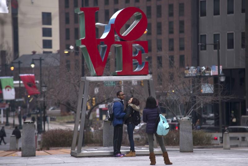 A young couple has their photo taken in front of Robert Indiana's iconic LOVE sculpture in Philadelphia, February 12, 2015. Reuters/Charles Mostoller  