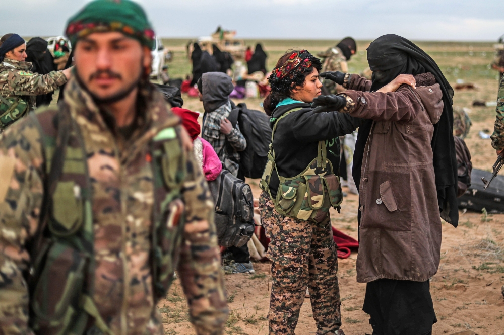 Civilians evacuated from the Islamic State (IS) group's embattled holdout of Baghouz wait at a screening area held by the US-backed Kurdish-led Syrian Democratic Forces (SDF), in the eastern Syrian province of Deir Ezzor, on February 27, 2019. AFP / Delil