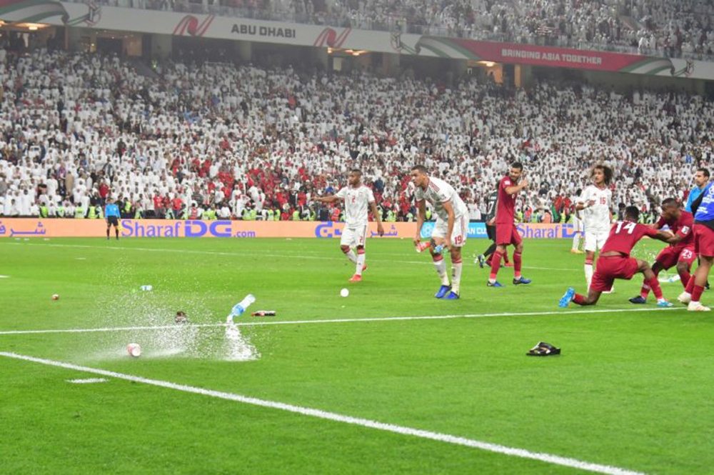 FILE PHOTO: Fans throw bottles and flip-flops at the pitch during the 2019 AFC Asian Cup semi-final football match between Qatar and UAE at the Mohammed Bin Zayed Stadium in Abu Dhabi on January 29, 2019. / AFP / Giuseppe CACACE