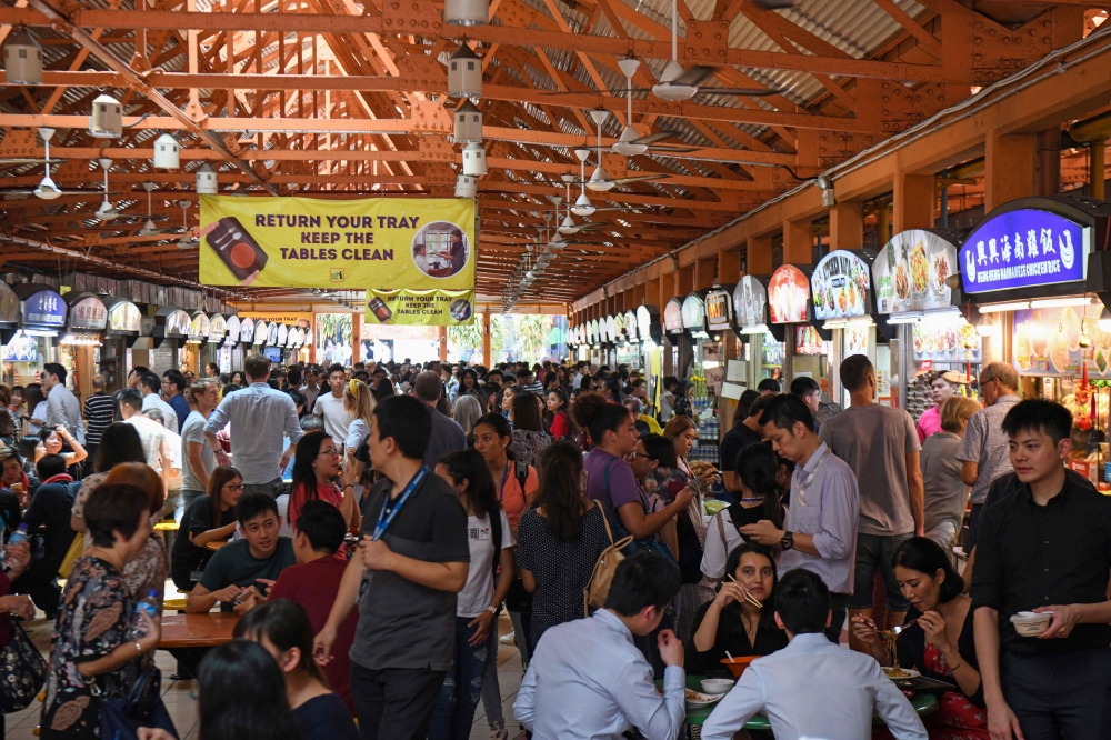 People gather at the Hawkers Centre at lunchtime in Singapore on March 28, 2019. AFP / Roslan RAHMAN