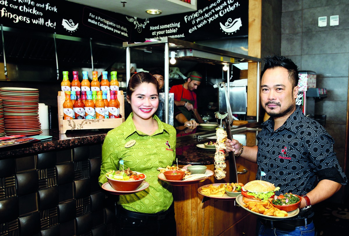 Nandos staff in new uniform with dishes introduced in the new menu. Pic: Qassim Rahmatullah / The Peninsula