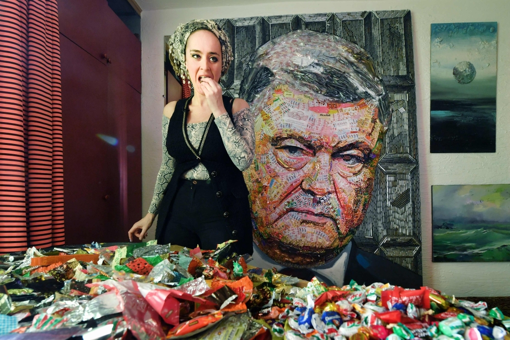 Ukrainian artist Daria Marchenko eats a candy as she creates a large-scale artwork entitled 