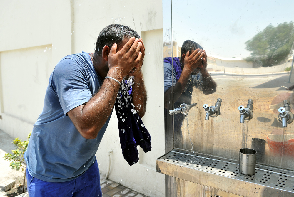 FILE PHOTO: Beating The Heat: A resident cooling-off with cold water from water-cooler kept outside a Masjid in Doha. August 12, 2018. Salim Matramkot © The Peninsula.