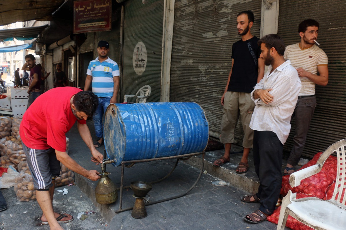 FILE PHOTO: Syrian merchats sell fuel at a market in an opposition-held district in Syrias' northern city of Aleppo on August 12, 2016. AFP