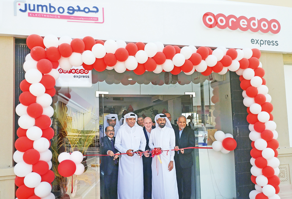 The officials cutting a ribbon at the opening of Ooredoo Express shop.