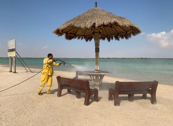 A worker busy cleaning a beach premise. 