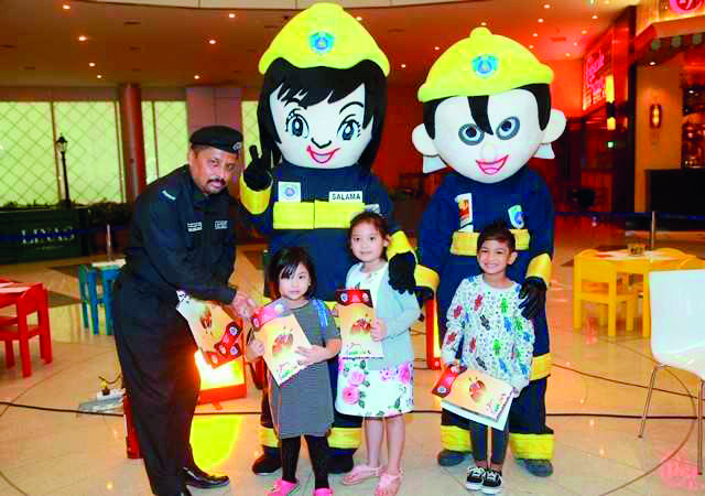 The officials of the General Directorate of Civil Defence educate children on safety measures during an awareness campaign at the Doha Festival City. 