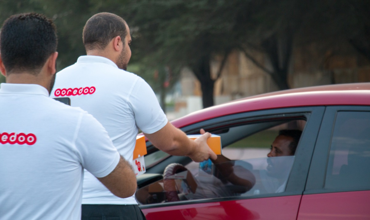 Ooredoo volunteers distributing dates and water on Doha Corniche.