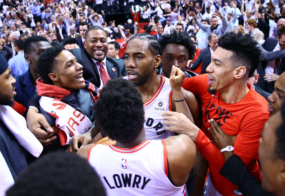 Kawhi Leonard #2 of the Toronto Raptors celebrates with teammates after sinking a buzzer beater to win Game Seven of the second round of the 2019 NBA Playoffs against the Philadelphia 76ers at Scotiabank Arena on May 12, 2019 in Toronto, Canada. AFP / Vau