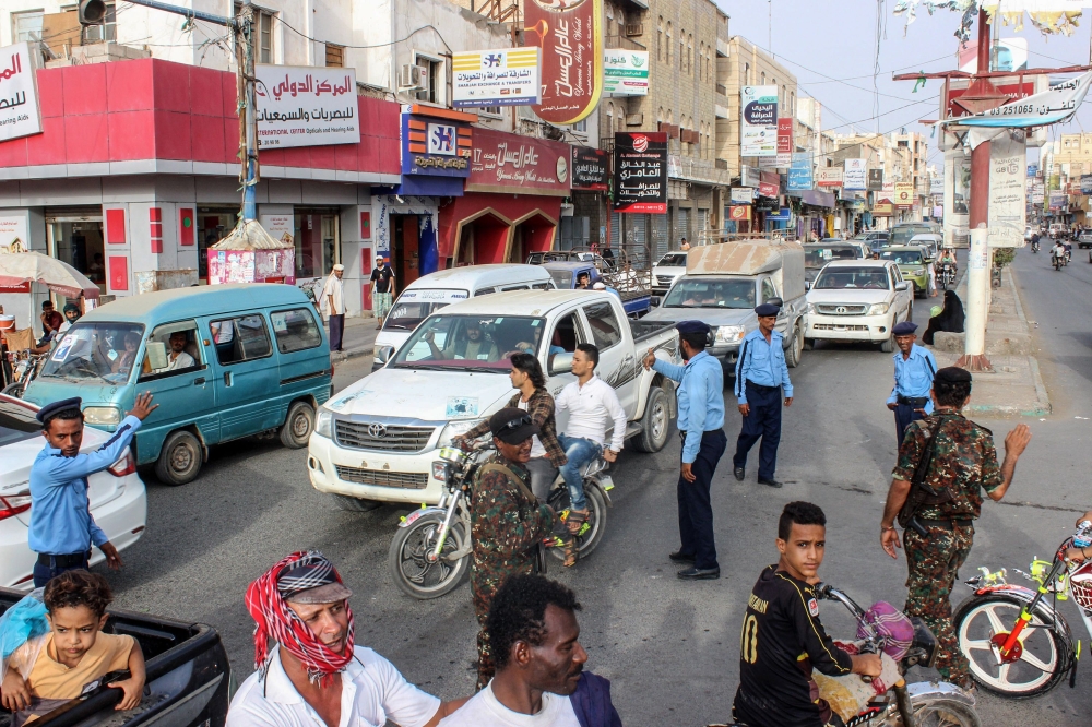 Yemeni policemen (in blue) and Huthi fighters control the traffic at the centre of the port city of Hodeidah, around 230 kilometres west of the capital Sanaa, on May 13, 2019. (AFP)