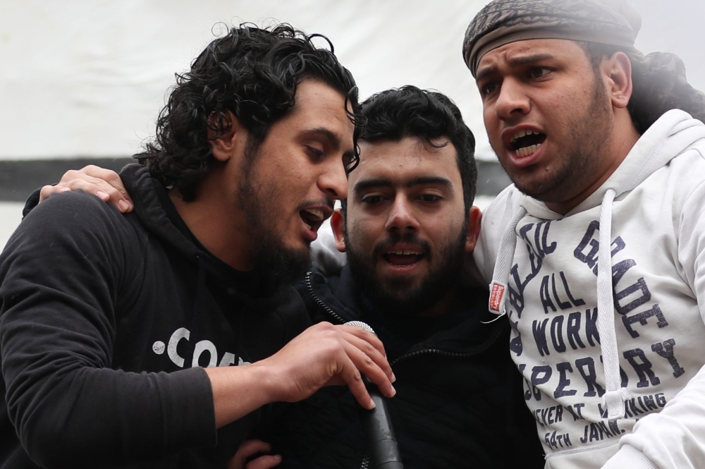 The late Syrian rebel fighter Abdel-Basset al-Sarout (L) singing during a rally to commemorate the beginning of the Syrian revoltion, in the town of Maaret al-Numan in the jihadist-held Idlib province. AFP / OMAR HAJ KADOUR