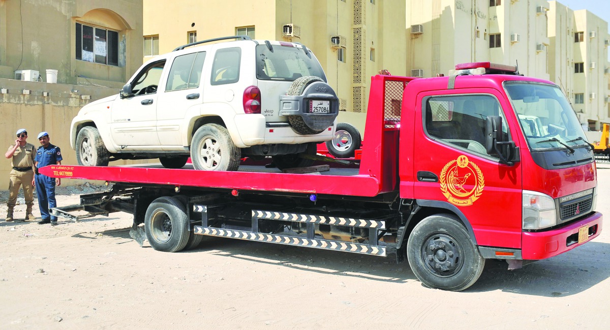 An abandoned car is being removed under a campaign launched by the Committee for Impounding Abandoned Vehicles at the Ministry of Municipality and Environment in the Old Airport area, yesterday. Pic: Baher Amin/The Peninsula