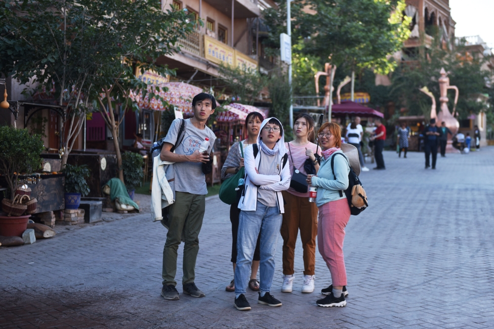 This photo taken on June 3, 2019 shows Malaysian tourists in the restored old city area of Kashgar, in China's western Xinjiang region. AFP / Greg Baker