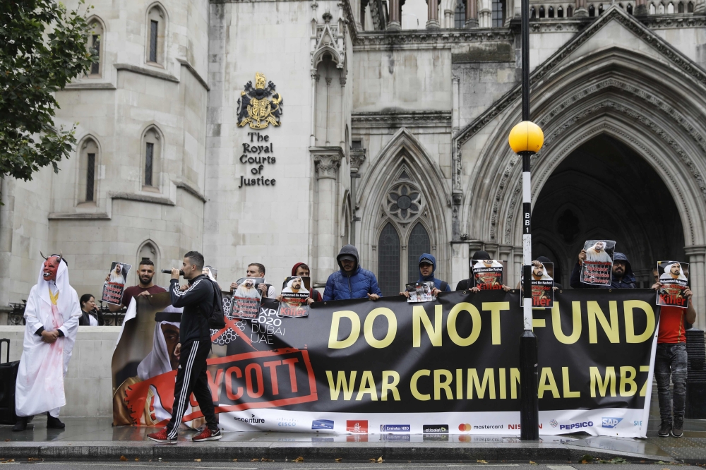 Demonstrators hold banners and placards as they protest against UAE rulers outside the High Court in London on July 30, 2019. (AFP / Tolga AKMEN)