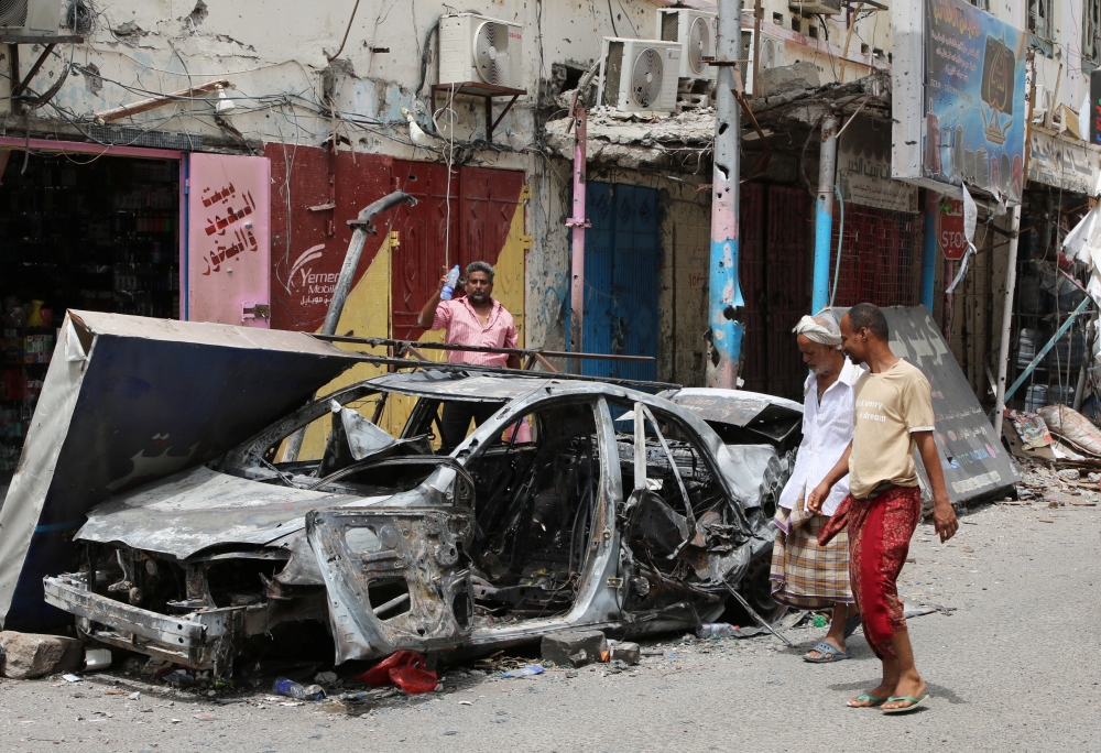 People check cars that were burned during clashes in Aden, Yemen August 12, 2019. REUTERS/Fawaz Salman