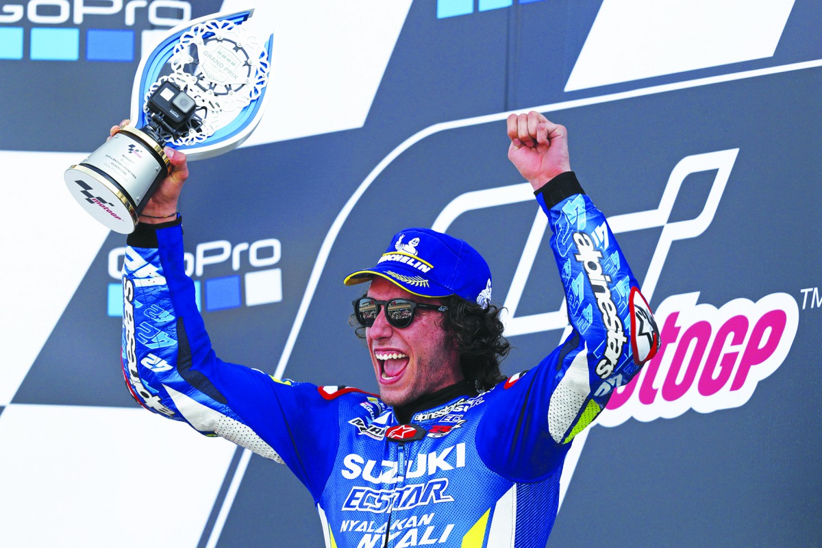 Suzuki Ecstar's Spanish rider Alex Rins holds up the trophy on the podium as he celebrates his victory in the Moto GP race of the British Grand Prix at Silverstone circuit in Northamptonshire, central England, on August 25, 2019. AFP / Adrian Dennis