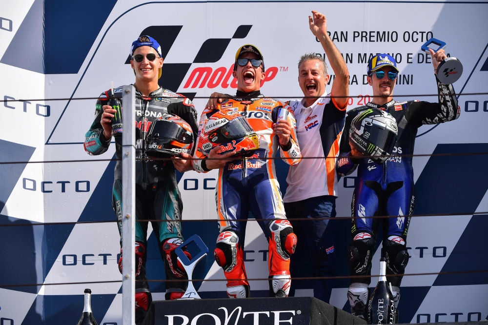 (FromL) Second-placed Petronas Yamaha SRT French rider, Fabio Quartararo, race winner Repsol Honda Team Spanish rider, Marc Marquez, third-placed Monster Energy Yamaha Spanish rider, Maverick Vinales (R) celebrate on the podium along with a Repsol Honda t