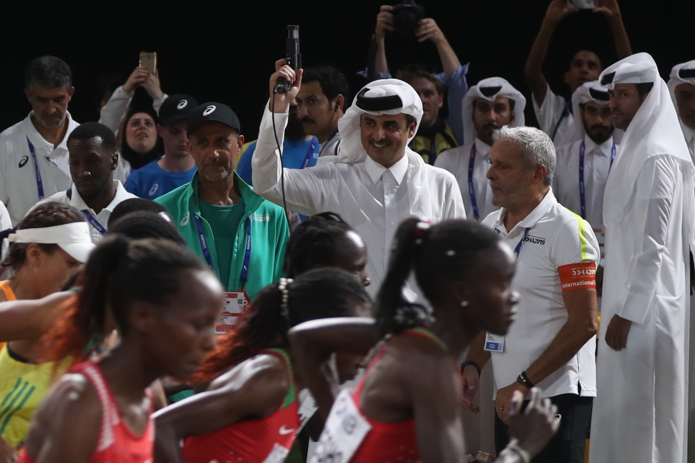 Amir HH Sheikh Tamim bin Hamad al-Thani (C) fires the staring gun for the Women's Marathon at the 2019 IAAF World Athletics Championships in Doha on September 27, 2019. AFP / Karim Jaafar 