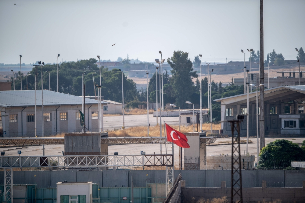 The border between Turkey and Syria, in Akcakale, Sanliurfa province, southeastern Turkey, shows a gate beytween Syria and Turkey in the Syrian town of Tel Abyad, on October 8, 2019. AFP / BULENT KILIC