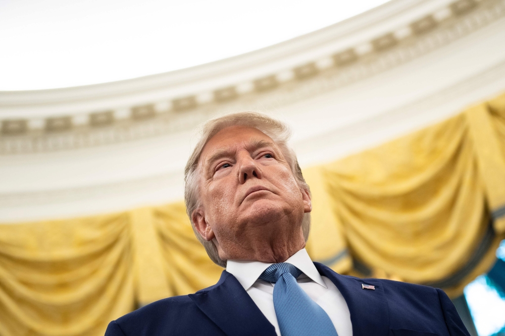 US President Donald Trump listens during a Presidential Medal of Freedom ceremony for Edwin Meese in the Oval Office at the White House in Washington, DC on October 8, 2019. / AFP / Brendan Smialowski