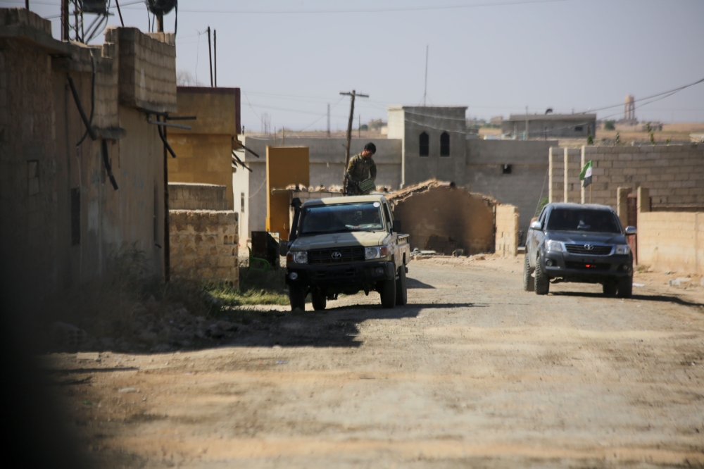 Turkish-backed Syrian rebels patrolling the town of Yabisah, west of Tal Abyad, on the border with Turkey.   AFP / Bakr ALKASEM