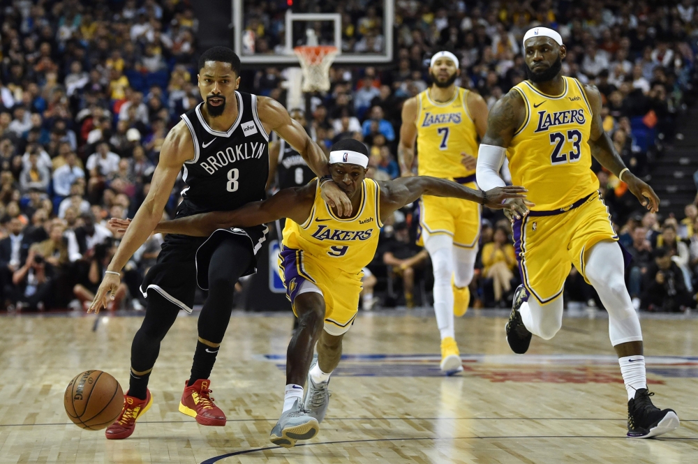 Spencer Dinwiddie of the Brooklyn Nets (L) drives the ball while is guarded by Rajon Rondo (R) of the Los Angeles Lakers during the National Basketball Association (NBA) pre-season match between the LA Lakers and Brooklyn Nets at the Mercedes Benz Arena i