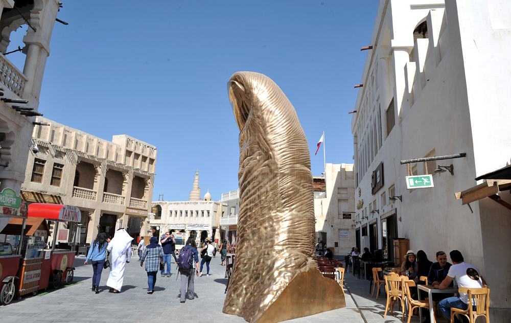 FILE PHOTO: Visitors walking past the Thumbs Up monument by French artist  César Baldaccini at the Souq Waqif in Doha. March 18, 2019. Salim Matramkot © The Peninsula