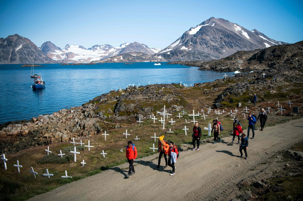 Andrea Fiocca (L), Italian researcher and tour guide leads a group of tourists as they arrive to Kulusuk (also spelled Qulusuk), a settlement in the Sermersooq municipality located on the island of the same name on the southeastern shore of Greenland on A