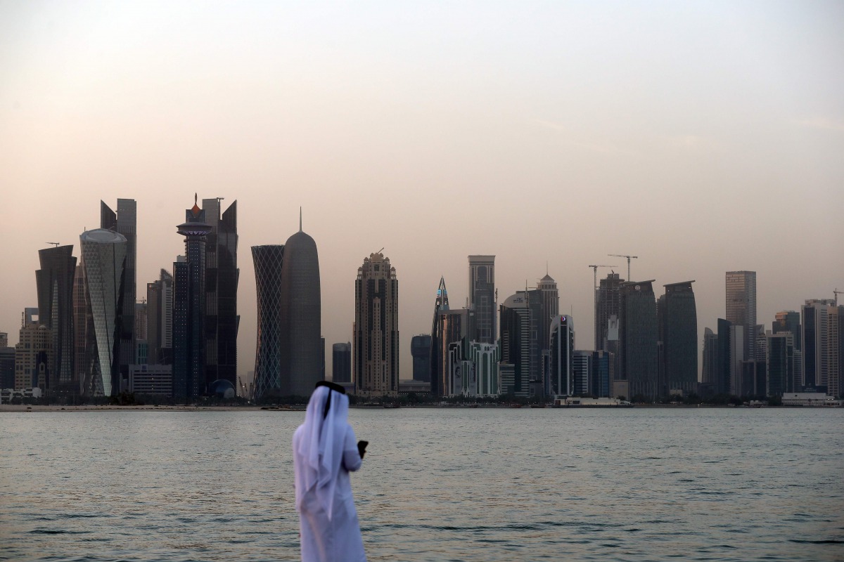 A man looks at his phone on Doha Corniche on July 2, 2017. (AFP) 