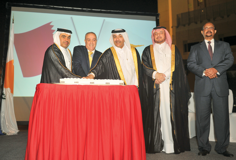 Minister of Commerce and Industry H E Ali bin Ahmed Al Kuwari (left) and Minister of Administrative Development, Labour and Social Affairs, H E Yousef Mohammed Al Othman Fakhroo (third right), cutting a cake with Ambassador of the Republic of Cyprus to Qa