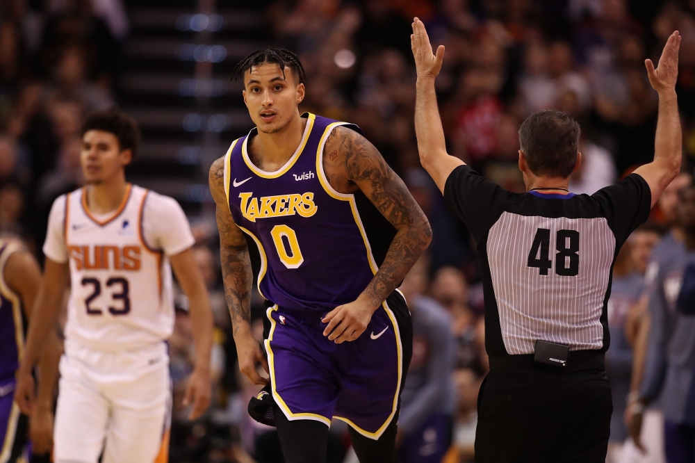 Kyle Kuzma #0 of the Los Angeles Lakers reacts after hitting a three point shot over Cameron Johnson #23 of the Phoenix Suns during the second half of the NBA game at Talking Stick Resort Arena on November 12, 2019 in Phoenix, Arizona. Christian Petersen/