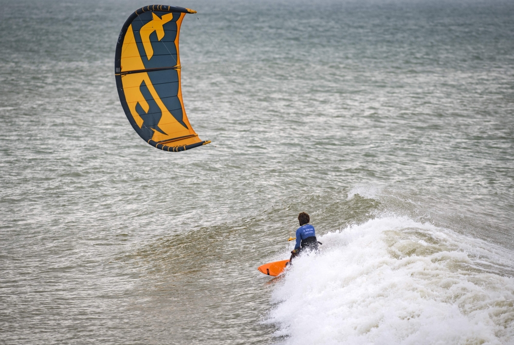 A picture taken on October 10, 2019, shows a kitesurfer riding waves at Dakhla beach in Morocco-administered Western Sahara. AFP / Fadel Senna