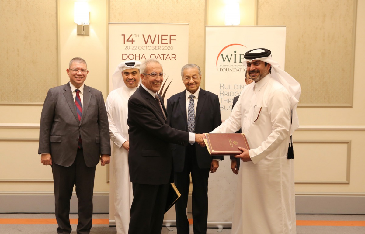 Nasser Al Muhannadi, Director of Finance, Ministry of Commerce and Industry (right) shaking hands with Datuk Syed Abu Bakar Almohdzar, Managing Director of WIEF foundation in the presence of visiting Malaysian Prime Minister H E Dr Mahathir Mohamad (secon