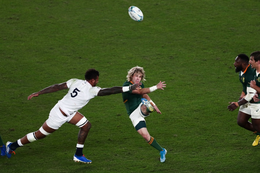 In this file photograph taken on November 2, 2019, South Africa's scrum-half Faf de Klerk kicks the ball past England's lock Courtney Lawes (L) during the Japan 2019 Rugby World Cup final match between England and South Africa at the International Stadium