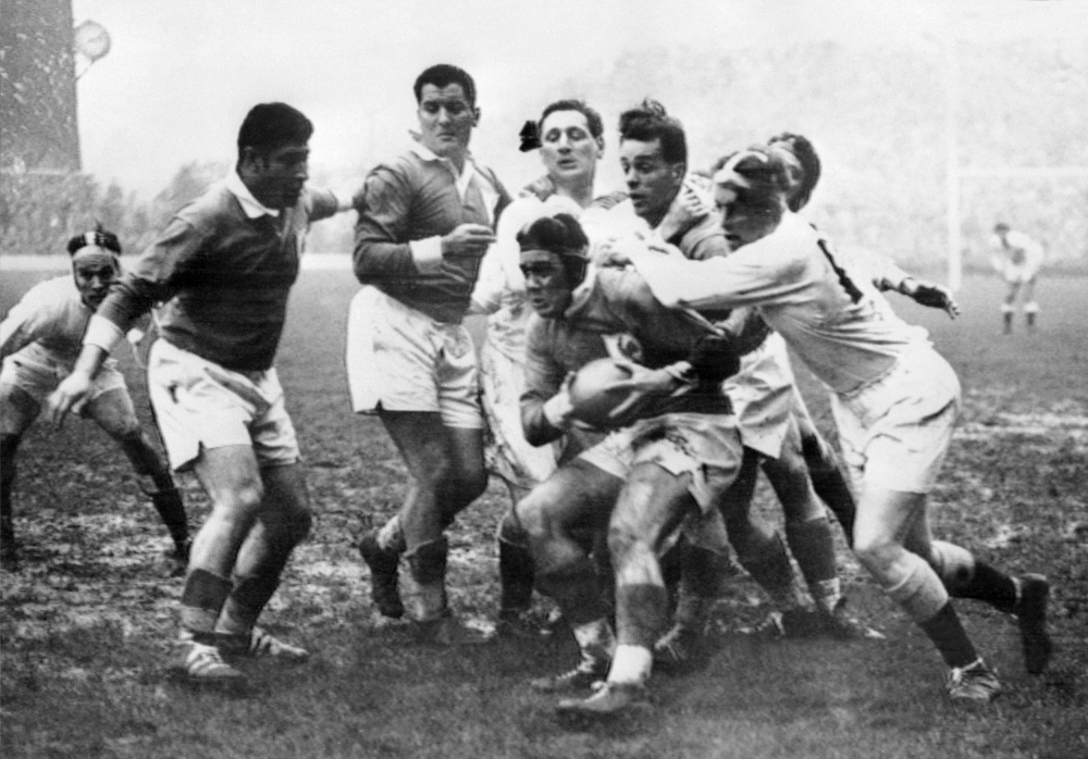 In this file photograph taken on February 23, 1957, France's captain Michel Celaya (C) is tackled by England's players during the Five Nations rugby union tournament match between England and France at Twickenham, west London.  AFP / Intercontinentale / S