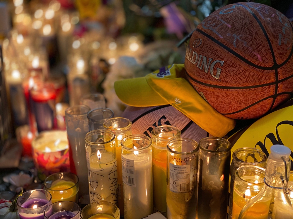 Candles are displayed at a makeshift memorial in front of a mural for former NBA and Los Angeles Lakers player Kobe Bryant in downtown Los Angeles on January 26, 2020, as people pay tribute to the former basketball player following his death in a helicopt