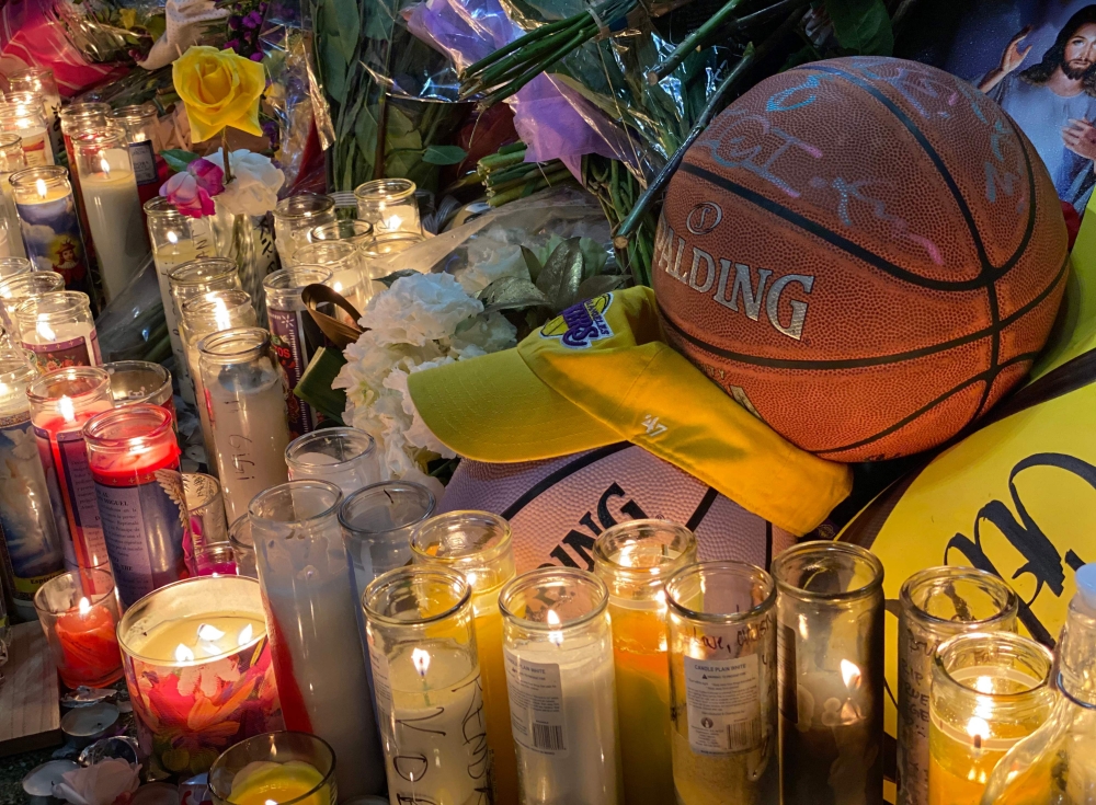 Candles are displayed at a makeshift memorial in front of a mural for former NBA and Los Angeles Lakers player Kobe Bryant in downtown Los Angeles on January 26, 2020 as people pay tribute to the former basketball player following his death in a helicopte