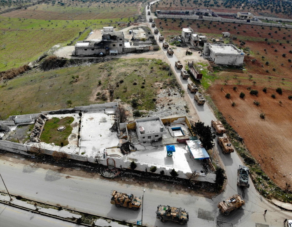 An aerial view taken on February 22, 2020 shows a Turkish military convoy that crossed into the Syrian territory via the Kafr Lusin border, passing near Syria's northwestern city of Idlib and heading toward the south of the Idlib province. / AFP / Omar HA