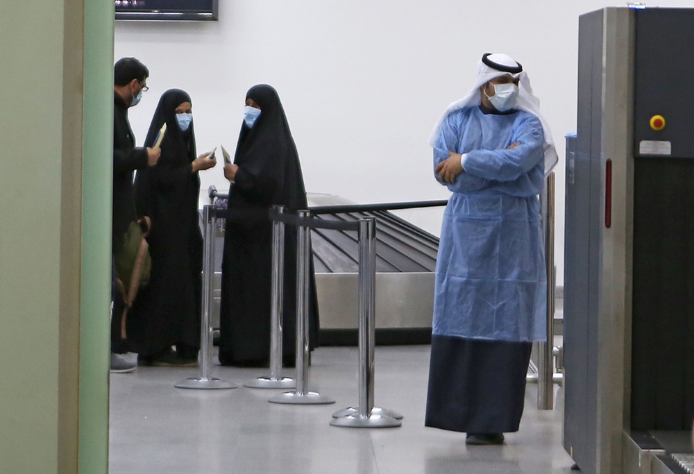 Kuwaitis coming back from Iran wait at Sheikh Saad Airport in Kuwait City, on February 22, 2020, before being taken to a hospital to be tested for coronavirus./ AFP / YASSER AL-ZAYYAT 