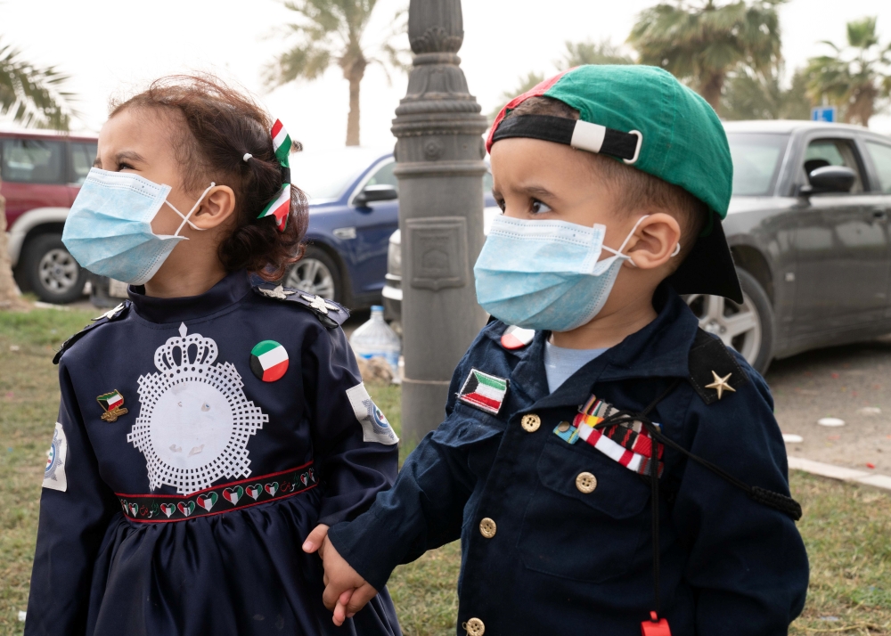 Kuwaiti kids wear protective face masks, following the outbreak of coronavirus, during celebrations of the 29th Kuwait Liberation Day from the Iraqi occupation, in Kuwait February 26, 2020. REUTERS/Stephanie McGehee