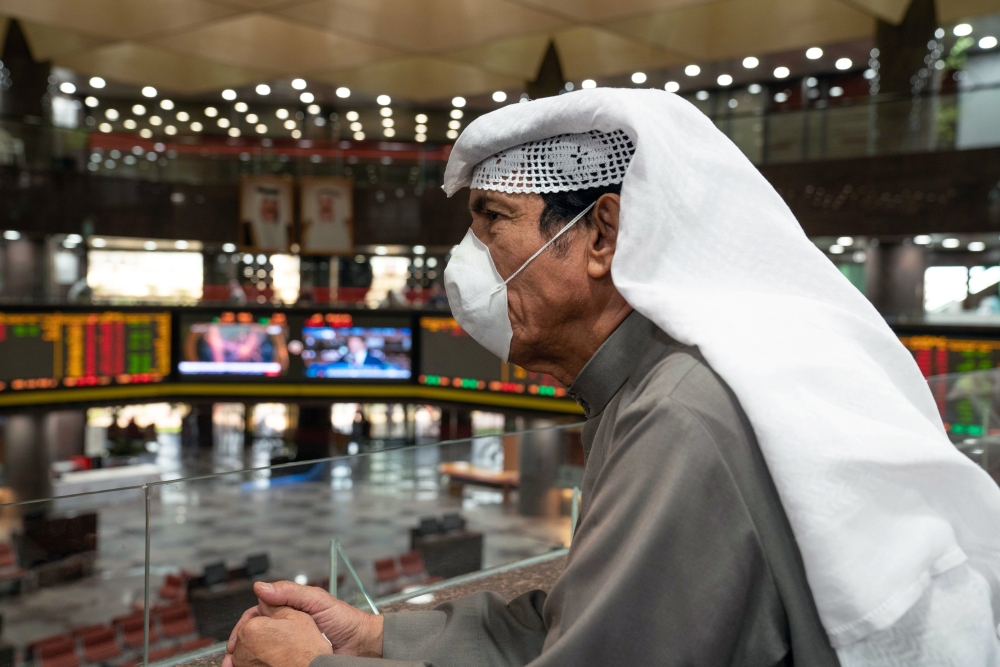 A Kuwaiti trader wears a protective face mask, following the outbreak of the new coronavirus, as he stands on the upper floor since the lower main hall is closed to traders at the Kuwait Boursa stock market trading in Kuwait city, Kuwait, March 1, 2020. R