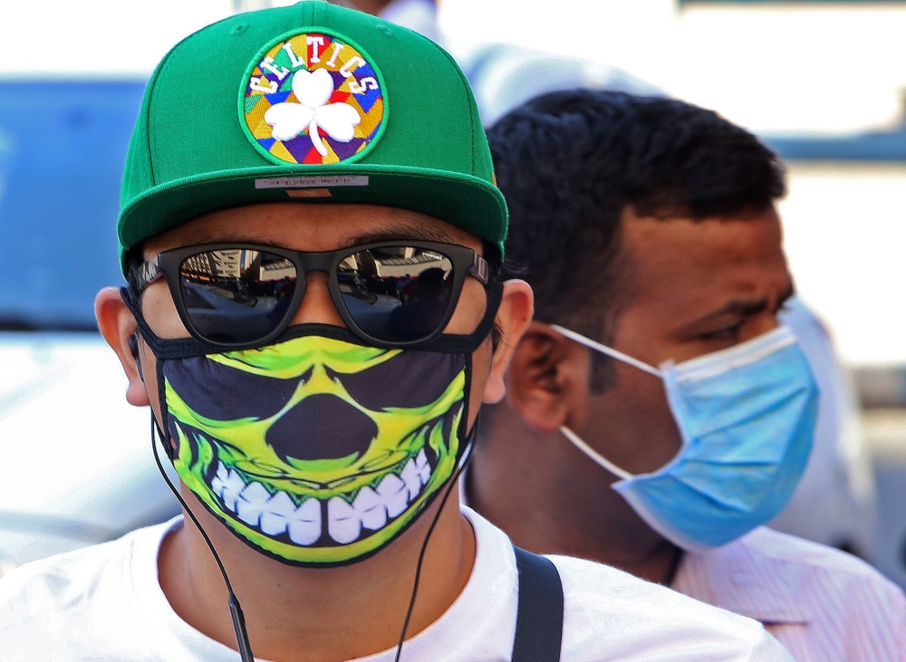 People wearing protective masks are seen on a street in Kuwait City on March 2, 2020, amid a global outbreak of the novel coronavirus. / AFP / YASSER AL-ZAYYAT
 